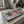 Vintage style metal sign with an image of colourful coffee cups on it, with rubber feet being used as a raised placemat in a kitchen setting