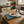 Kitchen scene with a wooden table, croissant on a plate, on top of a decorative vintage style metal sign with Hot Chocolate image 
