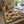 Decorative metal cheeseboard with cheeses image on it and crackers/biscuits on top of it, sitting on top of a kitchen counter.