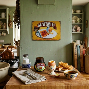 Kitchen counter with Marmite jar, eggs, toast, and a Marmite sign on the wall.