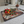 VINTAGE STYLE METAL PLACEMAT IN A KITCHEN SETTING WITH THE IMAGE OF THREE CHILLIS ON IT & A BOWL OF REAL CHILLIS & LEAVES ON TOP OF IT