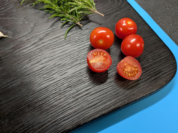 close up of Yakisugi oak serving board (medium sized) with cherry tomatoes & rosemary