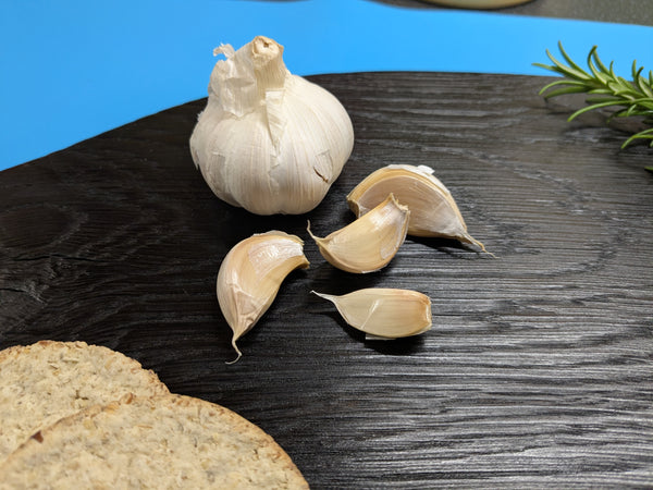 close up of Yakisugi oak serving board (medium sized) with garlic bulb