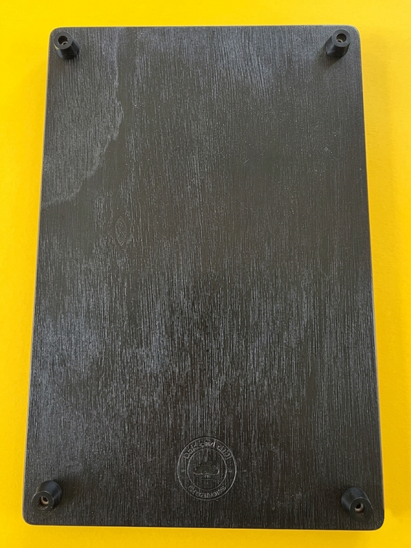 BACK OF THE METAL SIGN WALL ART SHOWING THE FOUR BLACK RUBBER FEET, ONE IN EACH CORNER MAKING IT INTO A PLACEMAT