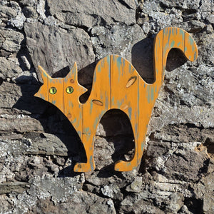 alley cat wooden wall art hanging on a stone wall