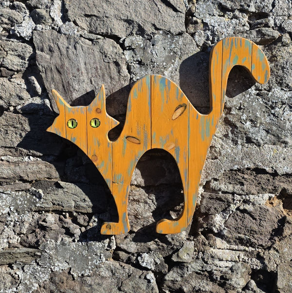 alley cat wooden wall art hanging on a stone wall