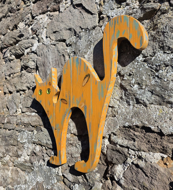 alley cat wooden wall art hanging on a stone wall other side view