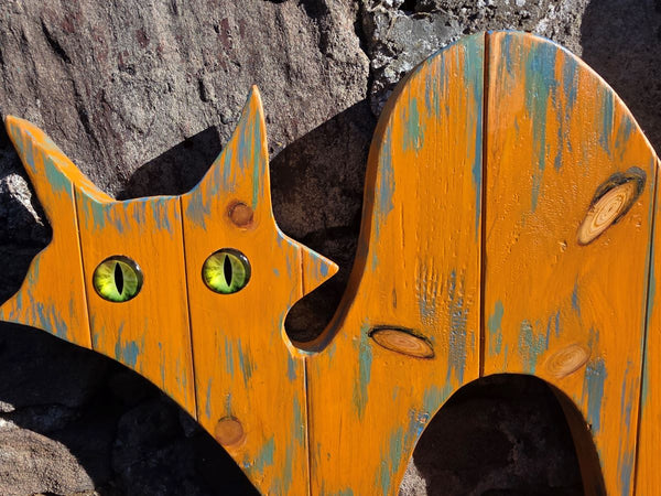 alley cat wooden wall art hanging on a stone wall close up photo