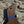 Close up view of Wooden Labrador Retriever wearing a blue decorative collar wall art against a stone wall