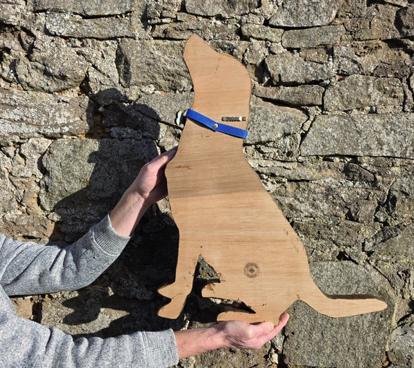 Reverse side of wooden wall art Labrador Retriever being held against a stone wall