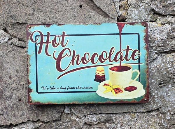 VINTAGE STYLE METAL SIGN (REPRODUCTION) HOT CHOCOLATE HANGING ON A STONE WALL