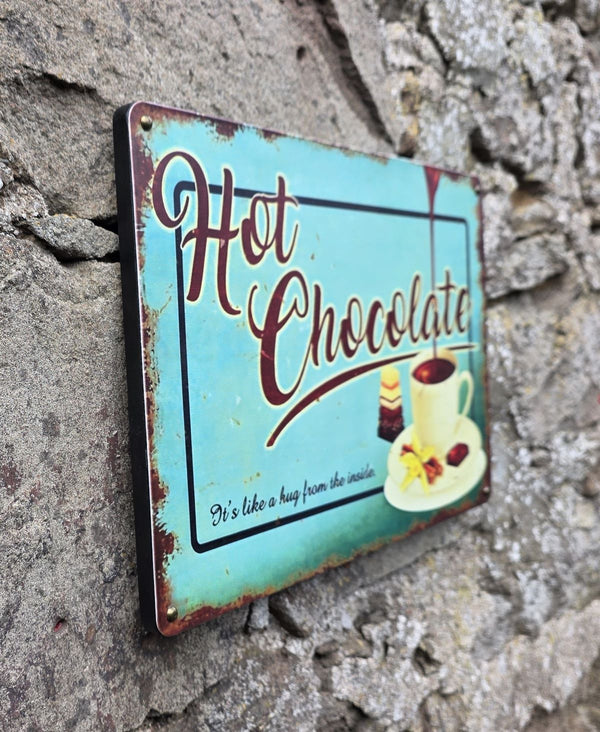 VINTAGE STYLE METAL SIGN (REPRODUCTION) HOT CHOCOLATE HANGING ON A STONE WALL - SIDE ANGLE VIEW
