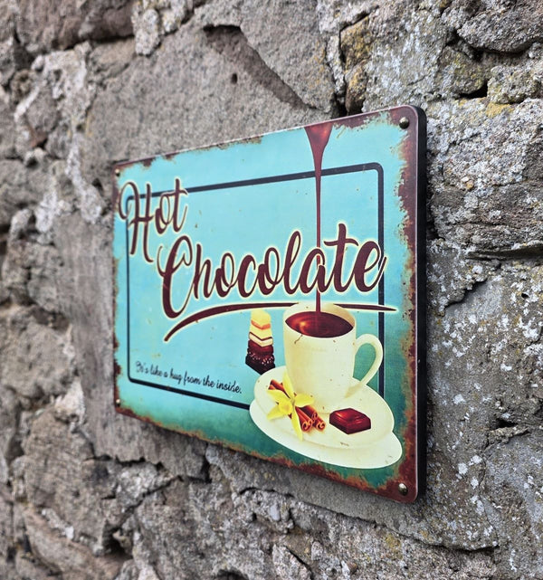 VINTAGE STYLE METAL SIGN (REPRODUCTION) HOT CHOCOLATE HANGING ON A STONE WALL - OTHER SIDE ANGLE VIEW