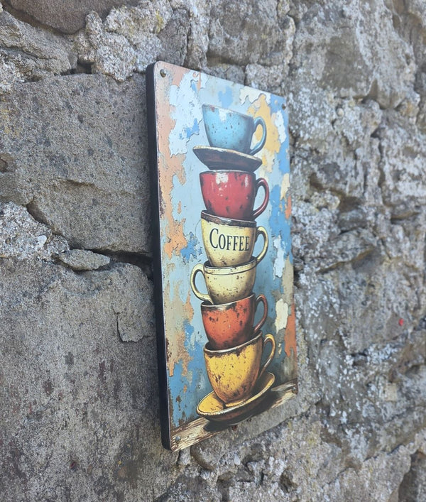 Decorative sign with stacked coffee cups on a stone wall viewed from a side angle