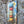 Vintage style metal sign with stacked coffee cups on a stone wall viewed from a different side angle