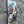 A side view of a decorative vintage style metal sign (repro) hanging on a stone wall with an image of cheeses and grapes on a cheeseboard