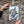 A rectangular vintage style metal sign  with a distressed white background featuring a black-and-white owl image and the text 'ARE YOU POOPING!' in black. The sign is photographed bing held up against a stone to show its sizing