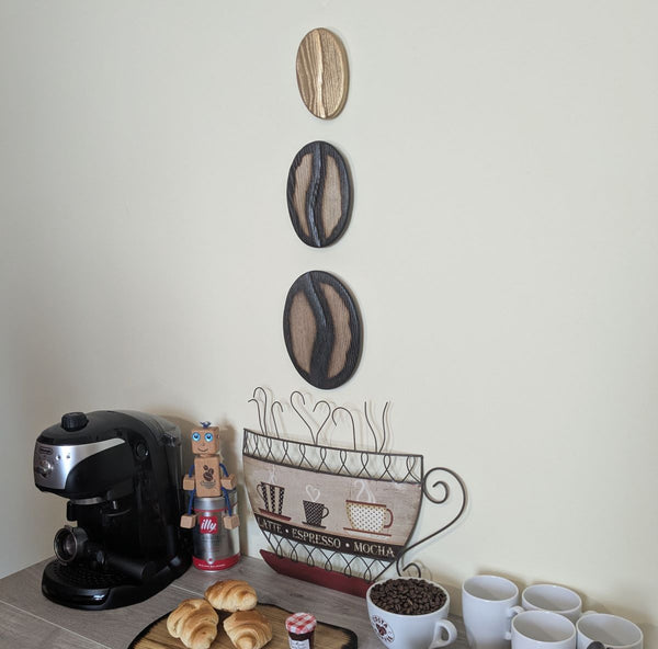 Coffee Bean Wall Art (Set of 3) including a Gold coffee bean - Ash wood Yakisugi Style displayed on wall in Coffee Shop setting viewed at an angle