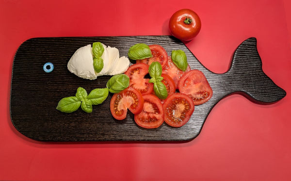 YAKISUGI WHALE STYLE ASH SERVING BOARD displayed with Capresse salad in a kitchen setting