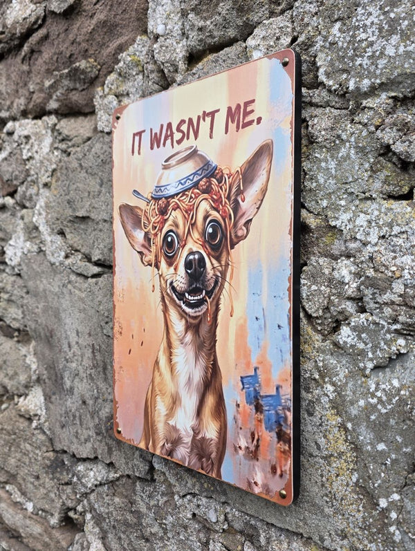 A VINTAGE STYLE METAL SIGN (REPRODUCTION) OF A  CHIHUAHUA DOG WITH AN UPTURNED BOWL OF SPAGHETTI ON ITS HEAD - DISPLAYED ON A STONE WALL AT A DIFFERENT ANGLE