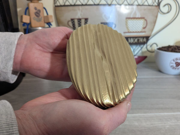 Gold coffee bean (small size) wall art decor up close showing Yakisugi style Douglas Fir wood being held to show sizing