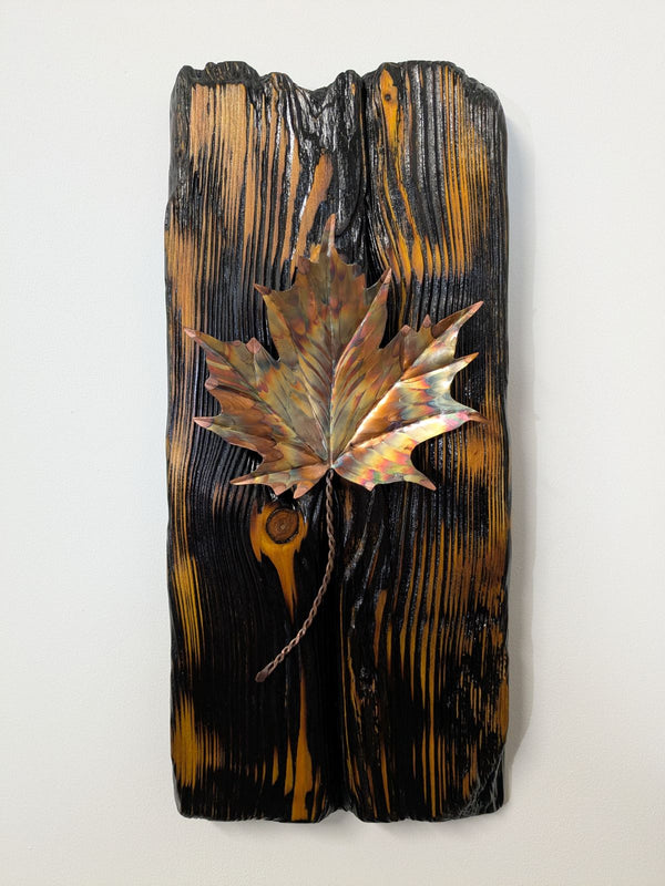 Douglas Fir & flame painted copper maple leaf wall art display piece hanging on a wall close up view