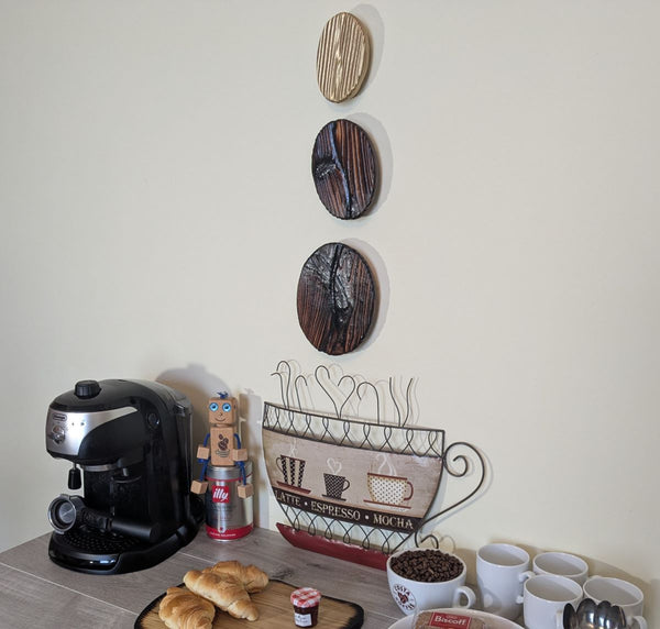 Coffee Bean Wall Art (Set of 3) including a Gold coffee bean - Douglas Fir wood Yakisugi Style displayed on wall in Coffee Shop setting viewed at an angle