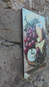 Video clip of Vintage style metal sign with an image of cheese & grapes on a cheeseboard, against a stone wall