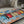AI generated video clip of coffee beans falling down on top of the vintage stlye metal sign with an image of colourful coffee cups in a stack